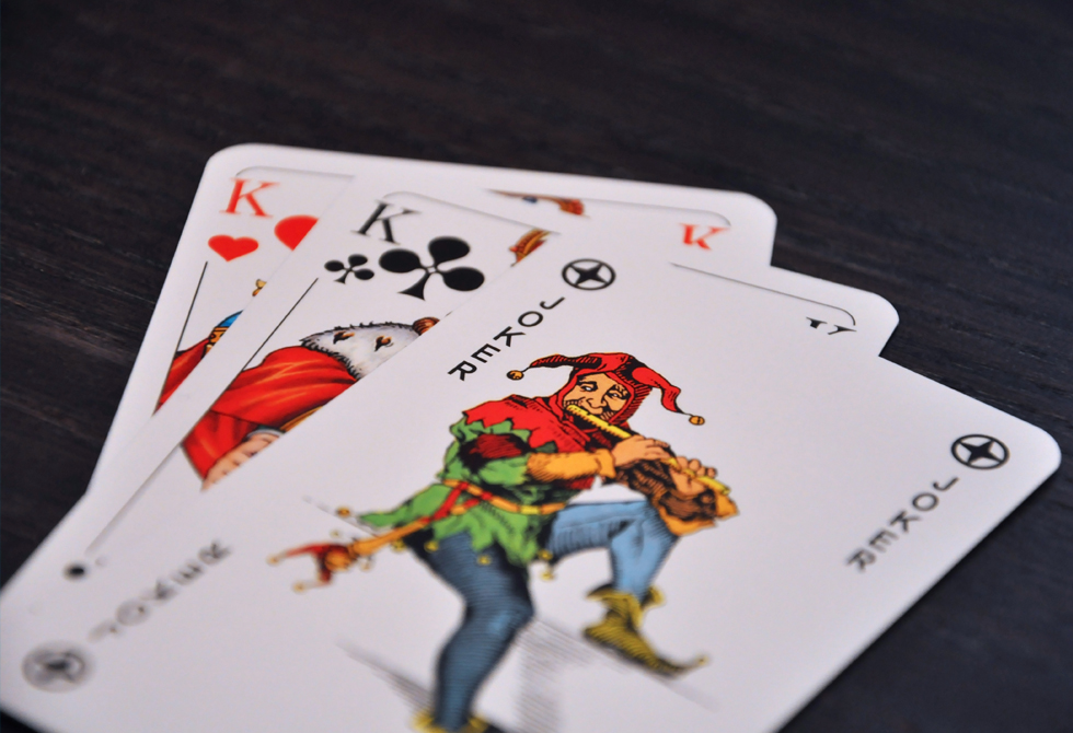 3 Canasta Karten liegen auf einem schwarzen Tisch, 2 Könige und ein Joker