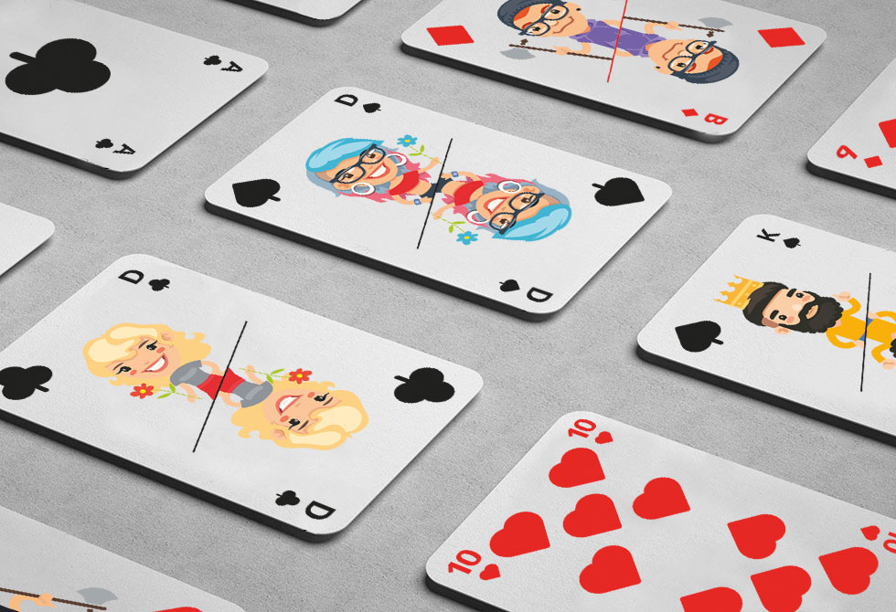 Selbst gestaltete Poker-Karten mit eigenen Motiven auf den Karten liegen aufgedeckt auf grauem Tisch.