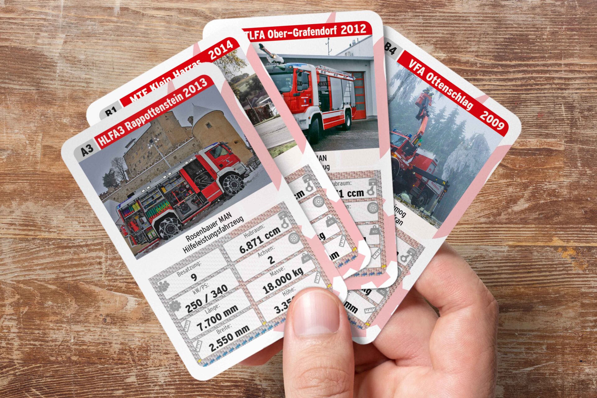 Auto-Quartett Karten selbst gestalten und drucken - Mann hält Karten von einem selbst gestalteten Feuerwehr-Quartett in der Hand.
