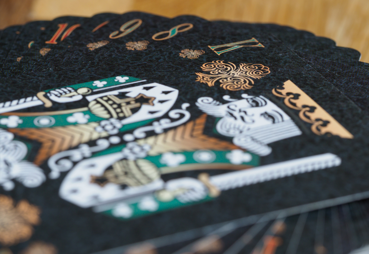 Auf einem Tisch liegen schwarze individuell gestaltete Pokerkarten mit goldenem Aufdruck