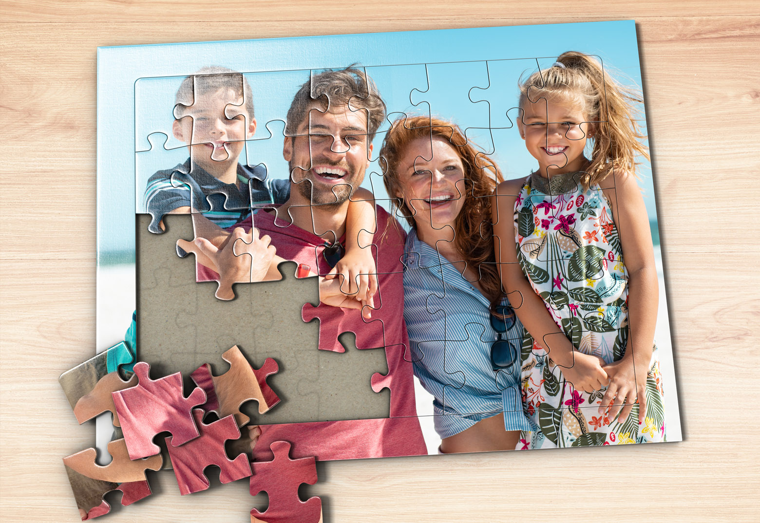Selbst gestaltetes Puzzle mit Foto liegt auf einem Holztisch. Das Motiv zeigt eine Familie im Urlaub.