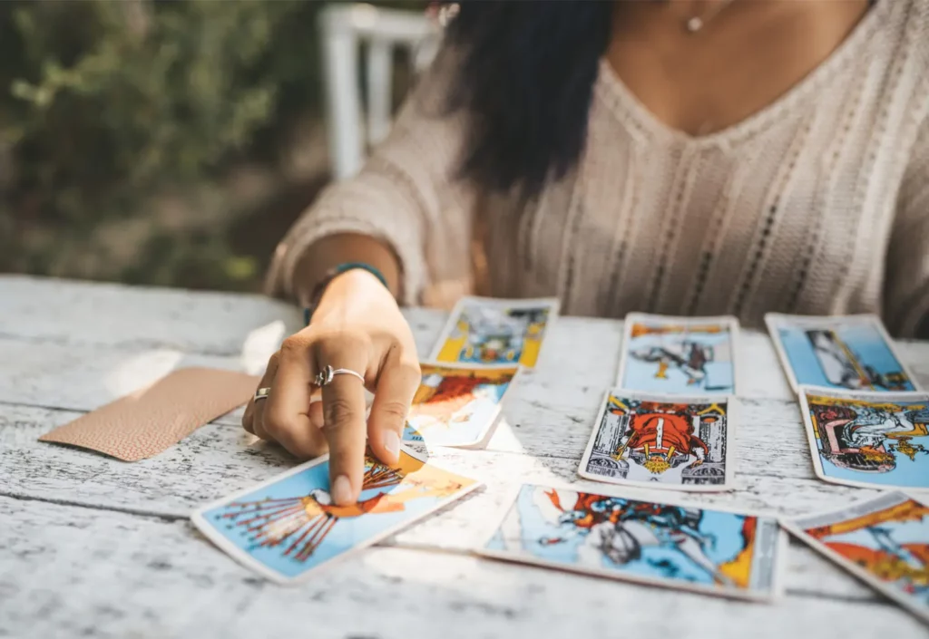 Tarot Karten bei MeinSpiel selbst gestalten und drucken. Frau legt eigene Tarot Karten auf einem weißen Holztisch.