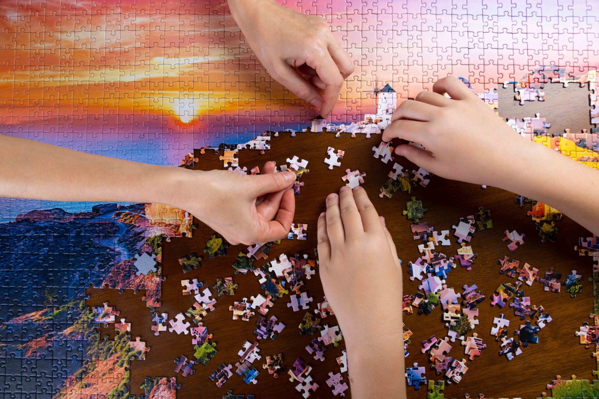 Zwei Personen setzen Puzzle-Teile auf einem Fotopuzzle mit einer Landschaft, gestaltet beim MeinSpiel, ein