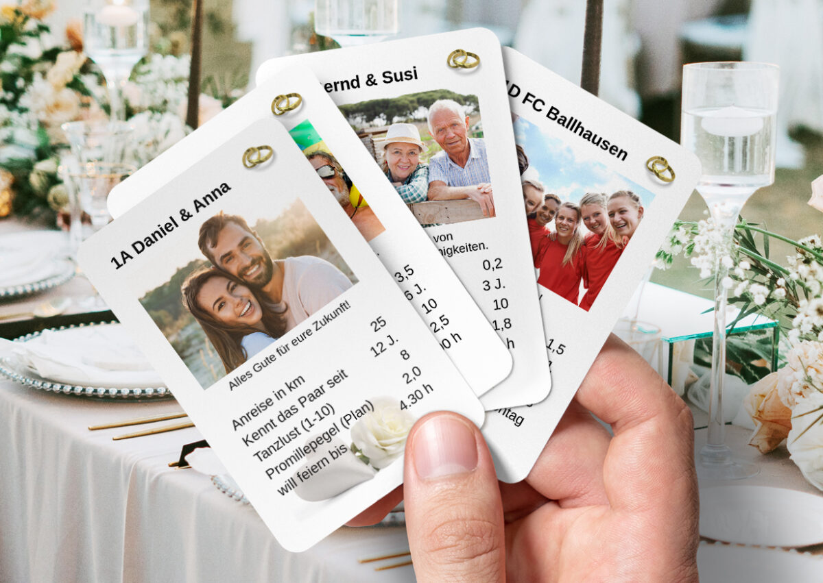 Eine Männerhand hält vier individuell gestaltete Hochzeitsquartett-Karten zwischen dem Daumen und dem Zeigefinger