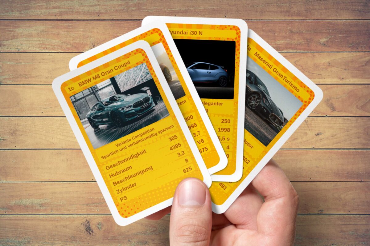 Auto-Quartett Karten selber online gestalten und drucken auf MeinSpiel. Eigenes Autoquartett im gelben Design wird auf der Hand gehalten.